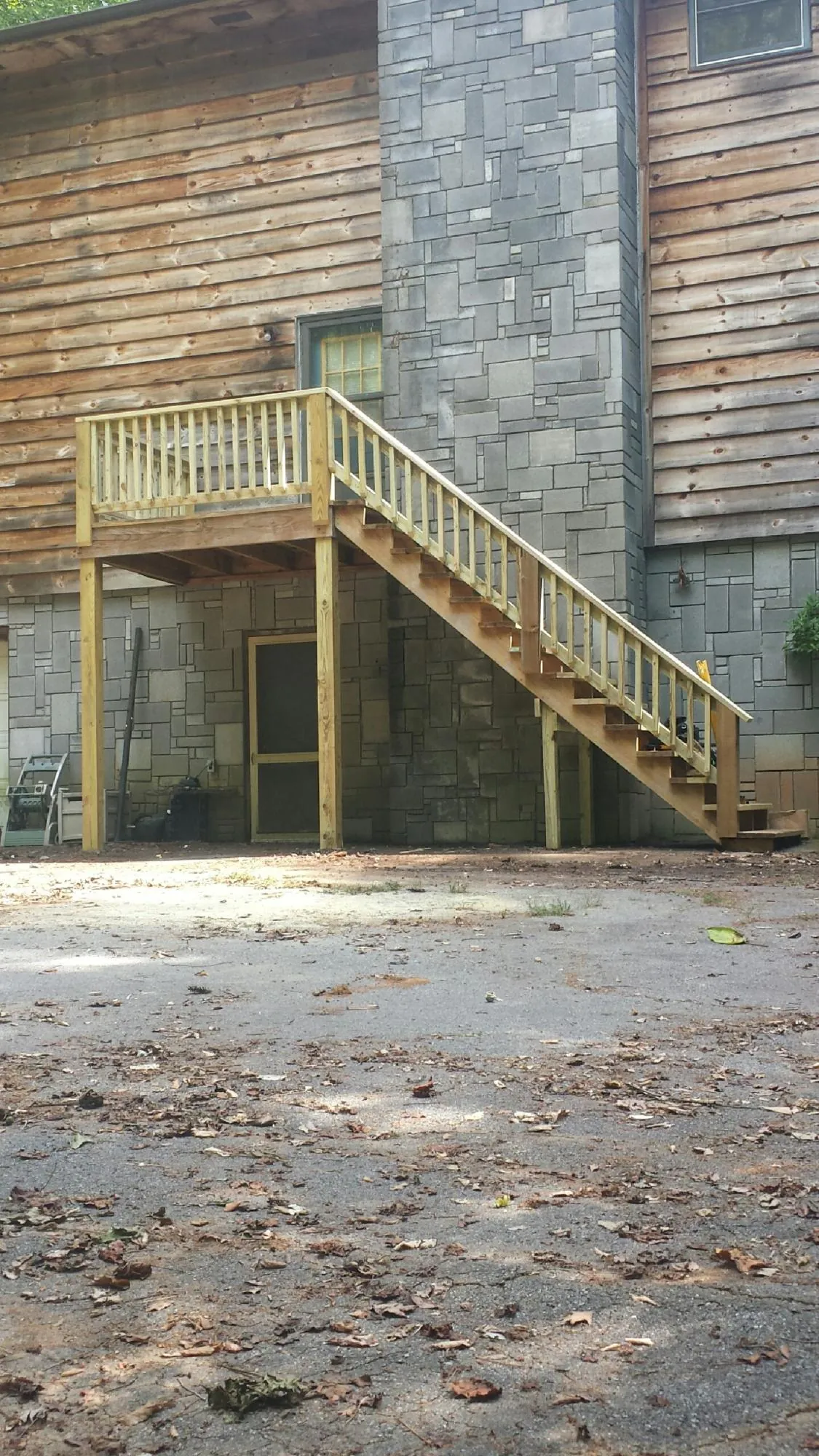 New pressure treated deck and stair landing on a log home in Earleton