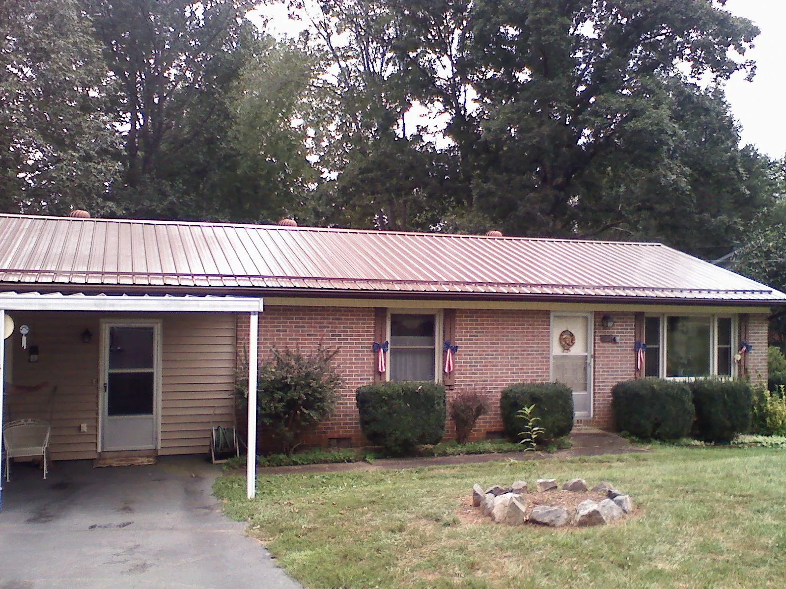 Bronze metal roof and carport on a brick ranch home — Roof Repair work by our crew in Earleton
